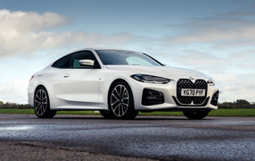 Белый автомобиль BMW 420i Coupé M Sport 2020 года на фоне неба