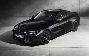 Черный автомобиль BMW M4 Competition X Kith 2020 года на фоне серой стены