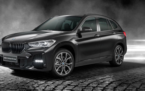 Черный автомобиль BMW X1 SDrive20i M Sport 25 Anos 2020 года в свете софитов