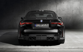 Черный BMW M4, 2021 года вид сзади на сером фоне