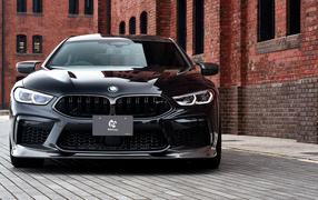 Черный автомобиль BMW M8, 2020 года у кирпичной цены
