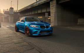 Синий автомобиль BMW M2 у моста 