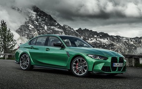 Green 2020 BMW M3 Competition car against the backdrop of a mountain