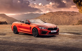 Красный кабриолет BMW M8, 2019 года у гор