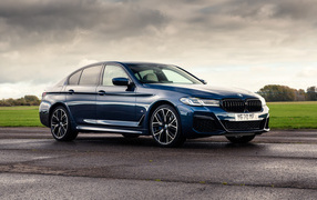 Стильный BMW 530e XDrive M Sport 2020 года на фоне грозового неба