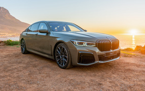 Stylish expensive car BMW 745Le, 2020 against a background of sunset