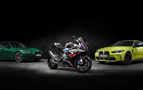 Two cars and a BMW motorcycle on a black background