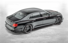 Черный автомобиль Mansory Bentley Flying Spur 2020 года на сером фоне