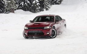 Красный автомобиль  Dodge Charger GT AWD, 2020 года едет по снегу