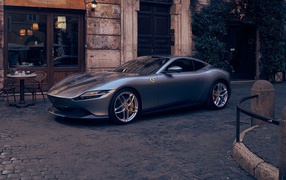 Серебристый автомобиль Ferrari Roma 2020 года у кафе