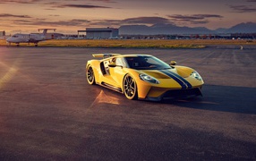 Желтый гоночный автомобиль Ford GT на взлетной полосе 