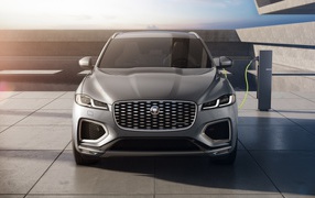 Серый автомобиль Jaguar F-Pace P400e AWD 2020 года на заправке