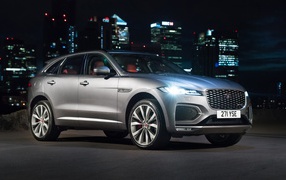 Silver Jaguar F-Pace R-Dynamic 2020 against the backdrop of a night metropolis