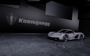 Спортивный автомобиль Koenigsegg Jesko Absolut 2020 года на фоне логотипа на стене