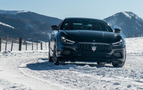 Black car Maserati Ghibli S Q4, 2020 rides on a snowy road