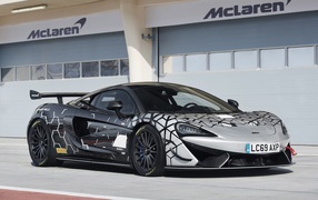 Гоночный автомобиль McLaren 620R у гаража