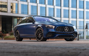Синий автомобиль Mercedes-AMG E 63 S 4MATIC+, 2021 года на фоне дома
