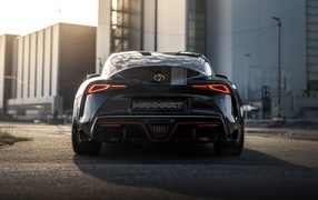 Черный автомобиль Manhart Supra GR 450 2020 года у домов