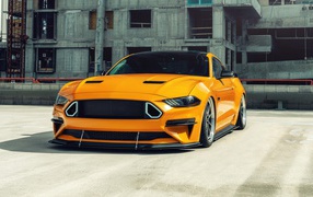 Оранжевый автомобиль  Mustang на стройке 