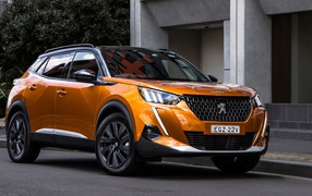 Оранжевый внедорожник Peugeot 2008 GT 2020 года у дома 