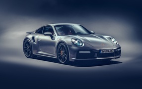 Автомобиль Porsche 911 Turbo S 2020 года на сером фоне