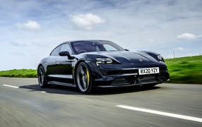 Черный автомобиль Porsche Taycan Turbo S 2020 года на скорости 