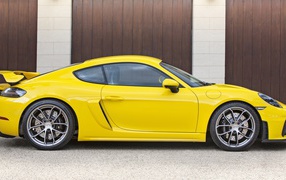 Желтый автомобиль Porsche 718 Cayman GT4 2020 года вид сбоку