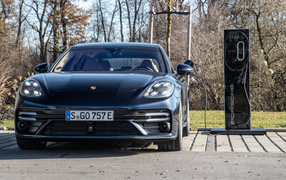 Черный автомобиль Porsche Panamera Turbo S E-Hybrid Sport Turismo 2021 года на заправке