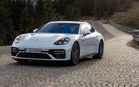 Белый автомобиль Porsche Panamera Turbo S E-Hybrid 2021 года на дороге