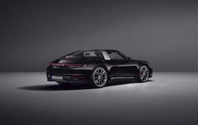Черный автомобиль Porsche 911 Targa 4S 2020 года вид сзади на сером фоне