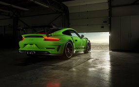 Зеленый автомобиль Porsche GT3 RS вид сзади