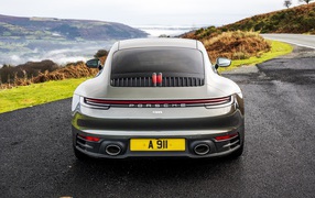 Автомобиль Porsche 911 Carrera на дороге у обрыва