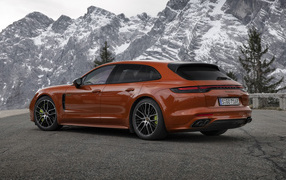 Красный автомобиль Porsche Panamera 4 E-Hybrid 2021 года на фоне гор