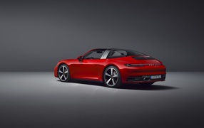Красный автомобиль Porsche 911 Targa 4, 2020 года на сером фоне вид сзади