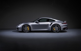 Серебристый автомобиль Porsche 911 Turbo S 2020 года вид сбоку 