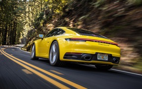 Желтый автомобиль  Porsche 911 Carrera 4S, 2020 года на трассе 