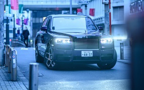 Автомобиль Rolls-Royce Cullinan с включенными фарами
