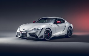 Серебристый автомобиль Toyota GR Supra 2L 2020 года на сером фоне
