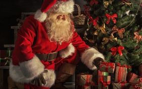 Santa Claus hides gifts under the Christmas tree