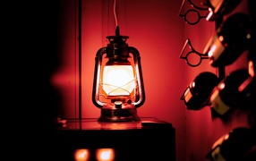 Керосиновая лампа стоит на столе в винном погребе 