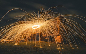 Яркие огненные искры фейерверка на развалинах