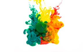 Зеленая и желтая краска растворяются в воде на белом фоне