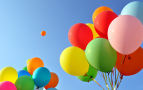 Много разноцветных воздушных шаров на голубом фоне