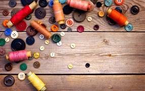 Разноцветные пуговицы и нитки лежат на столе