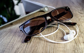 Солнечные очки с наушниками на столе