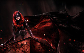 Супергерой Бэтвумен в черном плаще на крыше