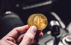 Две монеты биткоин в руке 