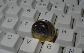 Two zloty coin lies on the keyboard