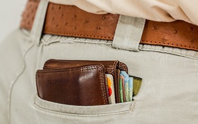 Кошелек с деньгами и карточками в кармане брюк 