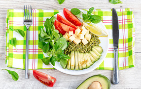 Аппетитные  свежие овощи с сыром и лимоном на тарелке 